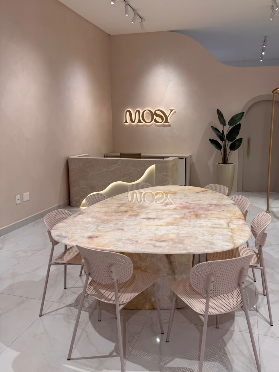 Mesa de mármore e salão do Mosy Studio em Itapema